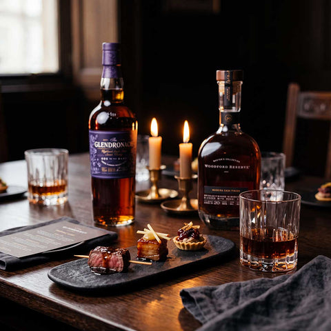 The GlenDronach Ode to the Dark and Woodford Reserve Madeira Cask Finish at a candlelit table with canapés